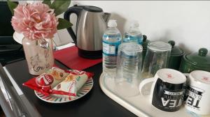 a counter with a tray of water and a vase with a flower at Spacious Double Room in Anfield in Liverpool