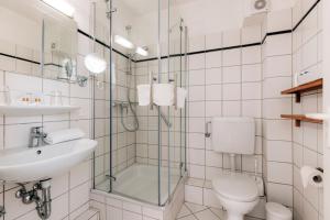 a bathroom with a toilet and a sink and a shower at Hotel Gorch Fock in Timmendorfer Strand