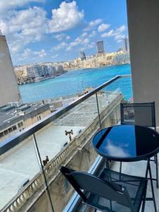 a balcony with a table and a view of the ocean at Sliema, Stylish 1 Bedroom Apartment with Parking. in Sliema