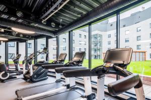 een rij cardio-apparaten in een fitnessruimte met een groot raam bij Park Inn by Radisson Danube Bratislava in Bratislava