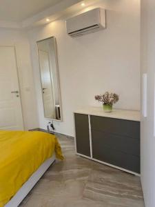 a bedroom with a yellow bed and a mirror at Sliema, Stylish 1 Bedroom Apartment with Parking. in Sliema