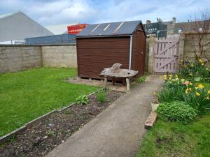 a garden with a bench and a wooden shed at Inviting light and airy 3-Bed Apartment in Wick in Wick