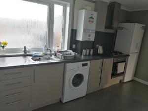 a kitchen with a sink and a washing machine at Inviting light and airy 3-Bed Apartment in Wick in Wick