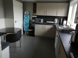 a kitchen with a sink and a table in it at Inviting light and airy 3-Bed Apartment in Wick in Wick
