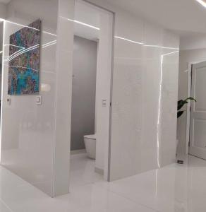 a bathroom with a toilet and a glass wall at Serenity Penthouse - The Pinnacle of Luxury in Maho Reef