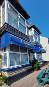 un restaurante con toldo azul en un edificio en Daffodil Guest House, en Filey