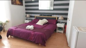 a bedroom with a purple bed with two towels on it at Spacious Double Room in Anfield in Liverpool