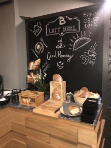 a bakery counter with bread and a sign on a wall at B LOFT HOTEL in Bursa