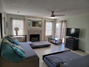 a living room with a couch and a tv at Five Minutes From the Beach in Navarre