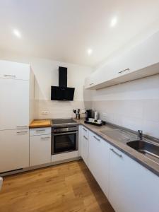 ベルンカステル・クースにあるFerienwohnung Moselの白いキャビネットとシンクのあるキッチン