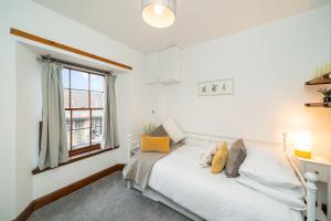 1 dormitorio con cama blanca y ventana en The Tollbooth, en Clackmannan