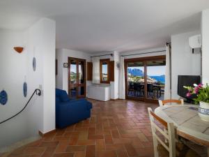 een woonkamer met een blauwe bank en een tafel bij Villa Majra - Klodge in Olbia