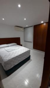 a bedroom with a bed and a projection screen at Aparta suit Rodadero in Gaira