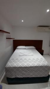 a bedroom with a white bed in a room at Aparta suit Rodadero in Gaira