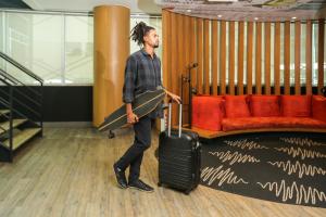 a man standing with a suitcase in a room at ibis Rio de Janeiro Santos Dumont in Rio de Janeiro