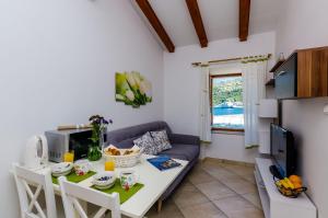 a kitchen and living room with a table and a couch at Orka Apartments in Dubrovnik