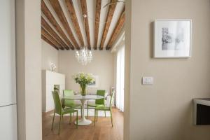 a dining room with a table and green chairs at Santa Fosca Design Apartment R&R in Venice