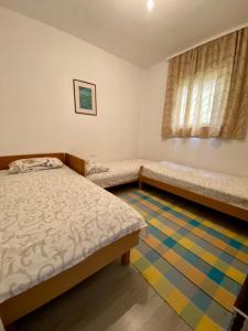 1 dormitorio con 2 camas y ventana en Holiday Home Oaza, en Čanj