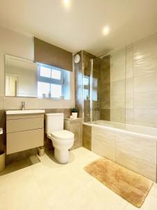 a bathroom with a toilet and a sink and a tub at PERFECT CENTRAL LOCATION- 5 minutes from TOWER BRIDGE ! 8 minutes walk from tube in London +11 photos