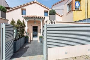 a fence in front of a house with a gate at Maison d' Orange - Chambres in Saint-Tropez