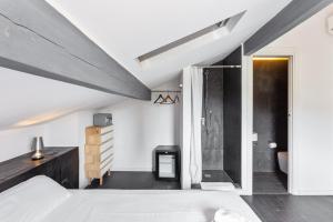 um quarto no sótão com uma cama e um chuveiro em Maison d' Orange - Chambres em Saint-Tropez