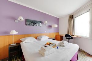 Habitación de hotel con 2 camas y toallas. en CMG - Cosy & charmant appartement Paris en Issy-les-Moulineaux