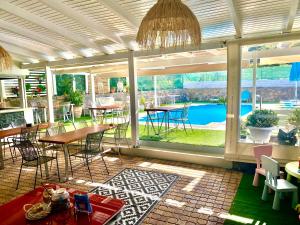 a patio with tables and chairs and a view of a pool at Attalos Apartments in Agia Pelagia