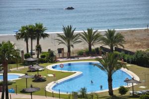 a view of a swimming pool and the beach at Don Juan Beach Resort in Estepona