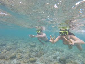 two people are swimming in the water at Phi Phi Relax Beach Resort in Phi Phi Islands