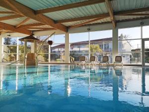 uma grande piscina com cadeiras num edifício em Vent d'Eden Park Hôtel em Saint-Hilaire-de-Riez