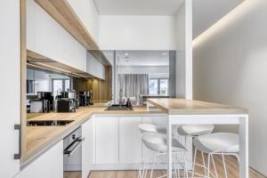 a kitchen with white cabinets and bar stools at Nsplace in Athens
