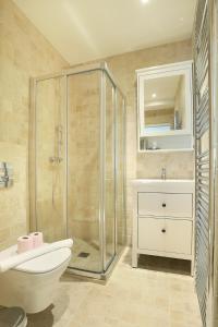 La salle de bains est pourvue d'une douche, de toilettes et d'un lavabo. dans l'établissement Résidence Grands Boulevards by Studio prestige, à Paris