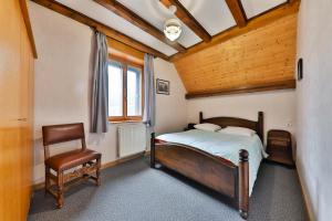 1 dormitorio con 1 cama y 1 silla en Gîte à La Montagne, en Labaroche