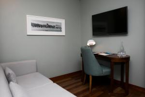 a living room with a television and a chair at Pousada de Lisboa - Small Luxury Hotels Of The World in Lisbon