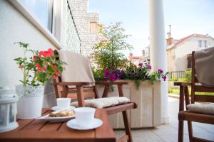 a table and chairs on a balcony with flowers at Apartment Larissa in Dubrovnik