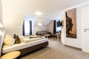 um quarto de hotel com uma cama e uma sala de estar em Amtsstüble Hotel & Restaurant em Mosbach