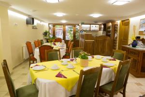 バダチョニトマイにあるDandelion Villa Gizellaのダイニングルーム(黄色のテーブルと椅子付)
