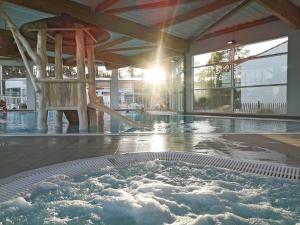 a swimming pool with a hot tub in a building at Vent d'Eden Park Hôtel in Saint-Hilaire-de-Riez