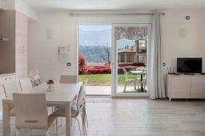 a kitchen and dining room with a table and a television at Appartamento Zerboni C1 in Lenno