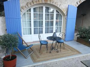 a patio with two chairs and a table in front of a window at la Cigalette in Peypin