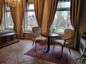 een woonkamer met een tafel en 2 stoelen bij The Hogg House - a city delight for two in Groningen