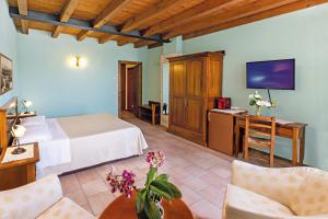 a hotel room with a bed and a tv at Agriturismo Casa Rosa in Novaglie