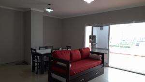 a living room with a red couch and a table at Departamento de 2 dormitorios con Terraza y Asador in Santiago del Estero