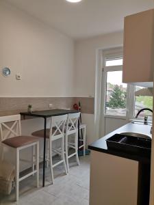 a kitchen with a table and chairs and a window at Apartman Maki in Sombor