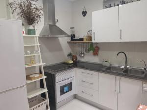 a kitchen with white cabinets and a sink at Ático de lujo en el centro in Aguadulce