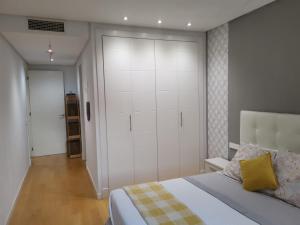 a bedroom with a bed and a large white closet at Ático de lujo en el centro in Aguadulce