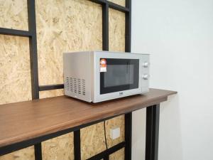 a microwave sitting on top of a wooden table at 53Ara impianS2 Dream guest Homes 芙蓉民宿 in Seremban