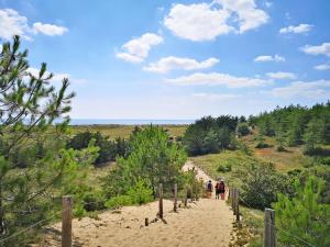 a group of people walking down a sandy trail at Vent d'Eden Park Hôtel in Saint-Hilaire-de-Riez
