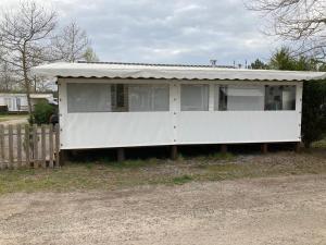 ein weißes Haus mit einem Zinndach in der Unterkunft Mobilhome TOUT CONFORT in Mimizan