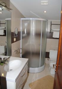 a bathroom with a shower and a sink and a toilet at Pensiune Heavens in Brăila